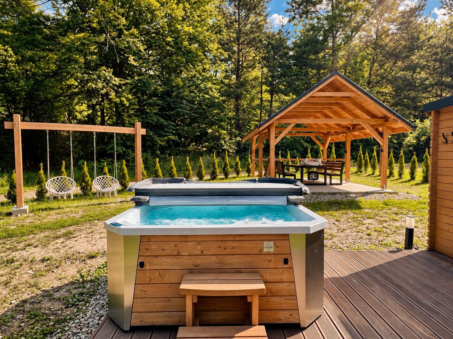 Jacuzzi na tarasie, w tle altana i huśtawki